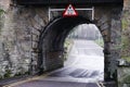 Bridge maximum head height sign and old stone arch Royalty Free Stock Photo