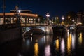 A bridge over the Amstel river and the lights reflected in the canal water , Amsterdam, the Netherlands.