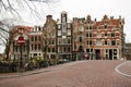 Bridge over a canal in the city of Amsterdam with the typical houses of the city Royalty Free Stock Photo