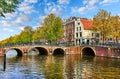 Bridge over channel in Amsterdam Netherlands houses river Amstel landmark old european city spring landscape. Royalty Free Stock Photo