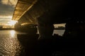 Bridge over Daugava River in Riga during sunset with golden reflections on water and structural silhouette showing engineering Royalty Free Stock Photo