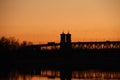 The bridge over the Dnieper against the background of an orange sunset. Kryukovsky road-railway bridge in Kremenchug, Ukraine.