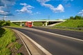 Bridge over an empty highway in the countryside, under a bridge passing two trucks Royalty Free Stock Photo