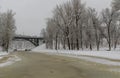Bridge over the freezing river in the winter park. trees in the snow Royalty Free Stock Photo
