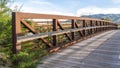 Bridge over a lake with view of mountain and valley under blue sky and clouds Royalty Free Stock Photo