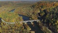 Bridge over the river, autumn forest Sigulda city nature, Gauya, 4K drone flight, bridge car drive from above