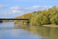 Bridge over the river. Autumn leaves on poplars along the river bank.