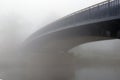 A bridge over a river, disappearing into the fog on a cold winters day. Upton Upon Severn, Worcestershire, UK Royalty Free Stock Photo
