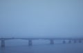 Bridge over the river in the industrial city in the winter during the fog Royalty Free Stock Photo