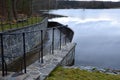 Bridge over safety spillway of the dam. stone bridge with natural paving of gray flat stones. on the edge of the retaining walls i Royalty Free Stock Photo