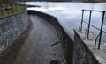 Bridge over safety spillway of the dam. stone bridge with natural paving of gray flat stones. on the edge of the retaining walls i Royalty Free Stock Photo