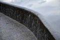 Bridge over safety spillway of the dam. stone bridge with natural paving of gray flat stones. on the edge of the retaining walls i Royalty Free Stock Photo