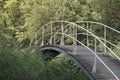 A bridge for pedestrians over a small creek at the forest edge Royalty Free Stock Photo