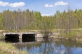 Bridge over a small river forest made of reinforced concrete channels