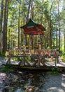 A bridge over a stream and a flag with a prayer. Prayer flags are hung on a small wooden bridge across the river. Royalty Free Stock Photo