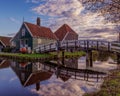 Bridge over a tranquil body of water, with traditional houses on the shore. Zaanse Schans