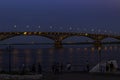 The bridge over the Volga river in the city of Saratov at night and people are walking along the embankment and admiring the bridg Royalty Free Stock Photo