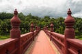 Bridge paited in red leading to a green park with palm trees Royalty Free Stock Photo