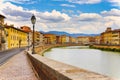 A bridge passes over the river and houses on both sides are overlooking the water. Pisa, Arno river, Ponte di Mezzo bridge and