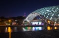 Bridge of Peace bow-shaped pedestrian bridge over the Kura river in Old Tbilisi town the Capital of Georgia. Twilight evening