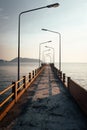 Bridge perspective passing through the frame with lampposts at sunset horizon Royalty Free Stock Photo