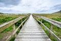 Bridge or pier over a dune on a sandy beach. Royalty Free Stock Photo