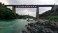 a bridge of rail or patri of train over a river, people are standing on it , made by british in 1900