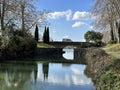 A bridge with a reflection in the water of Canal du Midi in Ponts Jumeaux, Toulouse, Occitania, France, February 2023 Royalty Free Stock Photo