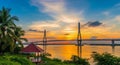 Cable-Stayed Bridge Spanning a Wide River at Golden Sunset with Palm Trees and Gazebo water Royalty Free Stock Photo