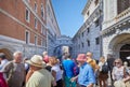 Bridge of Sighs people and tourists passing and looking at the famous bridge in a sunny day in Venice, Italy