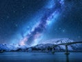 Bridge and starry sky with Milky Way over snow covered mountains Royalty Free Stock Photo