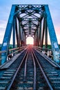 A bridge with train tracks and a sunset in the background Royalty Free Stock Photo