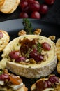 Brie cheese baked with nuts and grapes Royalty Free Stock Photo