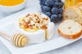 Brie cheese camembert with honey, nuts, baguette and fruit