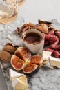 Brie and cheese with paprika, salami, figs, walnuts, honey and rose wine on a marble board. Food for a romantic date on a light