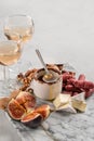 Brie and cheese with paprika, salami, figs, walnuts, honey and rose wine on a marble board. Food for a romantic date on a light