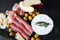 Brie cheese with salami, bacon, parmesan, olives, cut red apple and rosemary Royalty Free Stock Photo