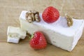 Brie cheese with walnuts and strawberries on wooden background