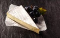 Brie Cheese Wedge and Black Grapes on Table