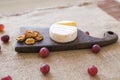 Brie type of cheese. Camembert cheese. Fresh Brie cheese on a wooden board with nuts and grapes. Italian, French cheese. Royalty Free Stock Photo