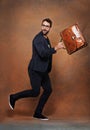 Briefcase, fashion and man in studio with glasses for trendy, edgy and stylish outfit with confidence. Goofy, satchel