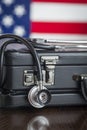 Briefcase and Stethoscope Resting on Table with American Flag Be