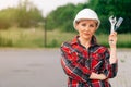 The brigadier is a young girl wistfully standing . A woman wearing a protective helmet. The concept of construction work Royalty Free Stock Photo