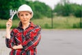 The brigadier is a young girl wistfully standing . A woman wearing a protective helmet. The concept of construction work Royalty Free Stock Photo