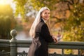 Long-haired pretty mature woman standing on the bridge Royalty Free Stock Photo