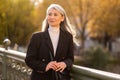 Long-haired pretty mature woman standing on the bridge Royalty Free Stock Photo