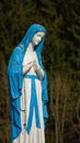 Brigh blue and white sculpture of Lady Mary praying