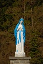 Bright blue and white statue of Lady Mary praying Royalty Free Stock Photo