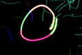 Bright abstract colorful pixelated circle of neon light on a black background and other colored abstract lines and spots
