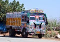 Bright agricultural truck Tata at an intrurban road.